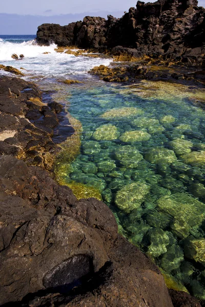 Nuageux plage eau lanzarote île rocher espagne pierre sk — Photo