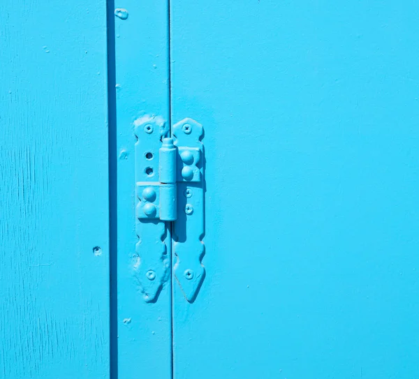 Na parede velha uma janela articulada madeira azul e metal enferrujado — Fotografia de Stock