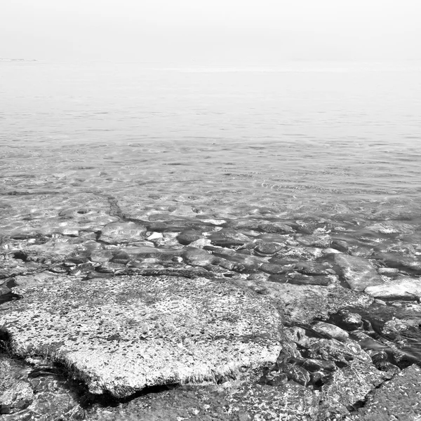 Piedra marrón en la costa amanecer y luz océano cielo blanco — Foto de Stock