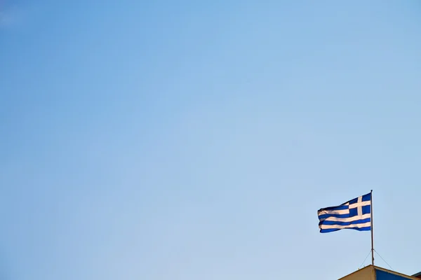 在蓝色的天空和旗杆的挥舞着希腊国旗。 — 图库照片