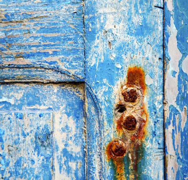 Mavi ahşap kapı ve paslı çivi boyası. — Stok fotoğraf