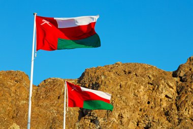 Umman dalgalanan bayrak ve bulutlu gökyüzü dağ
