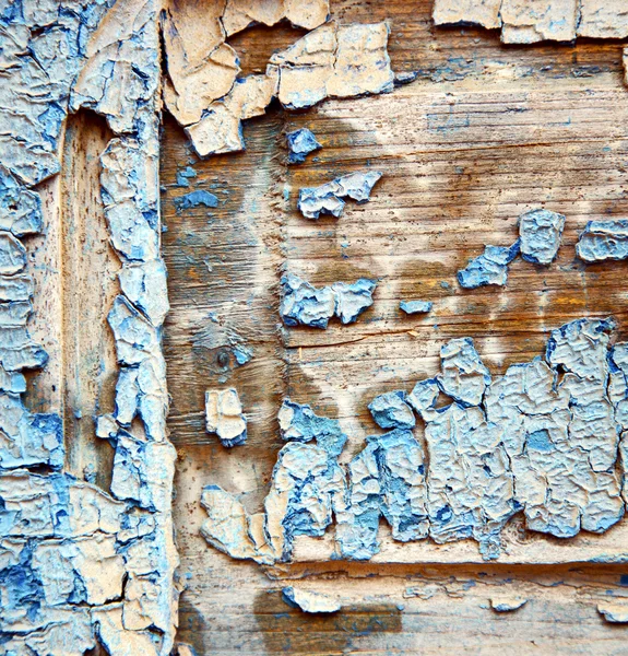 dirty stripped paint in the blue wood door and rusty nail