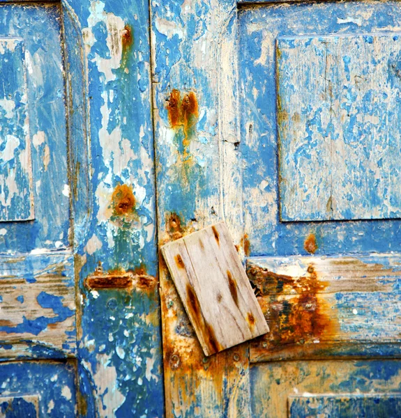 Sporca vernice spogliata nella porta di legno blu e chiodo arrugginito — Foto Stock