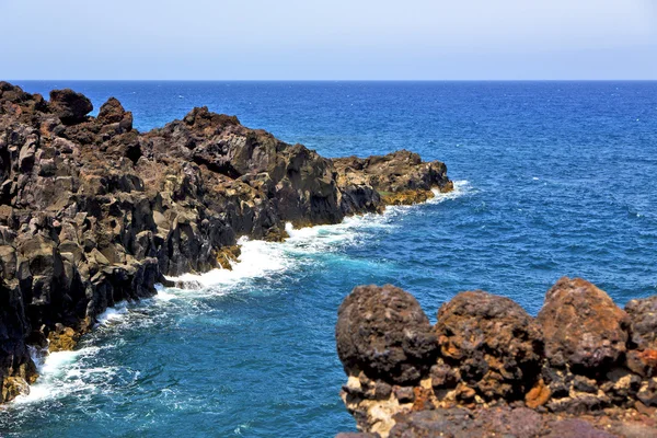 Hnědé skály v bílém pobřeží lanzarote Španělsko pláže kamenné vodě — Stock fotografie