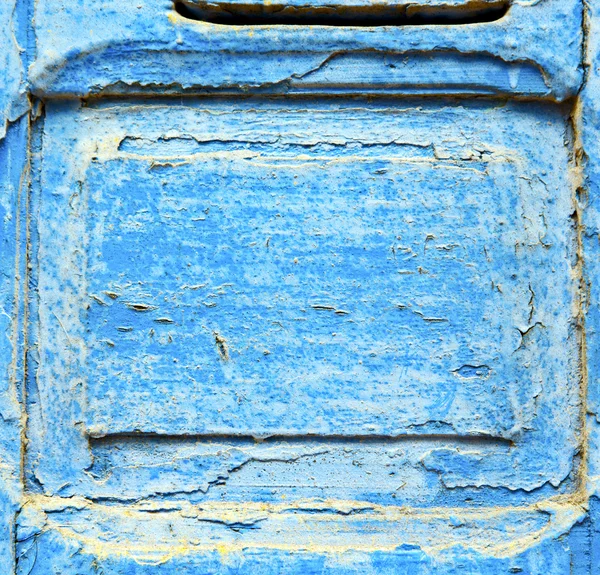 Pintura despojada na porta de madeira azul e prego enferrujado — Fotografia de Stock