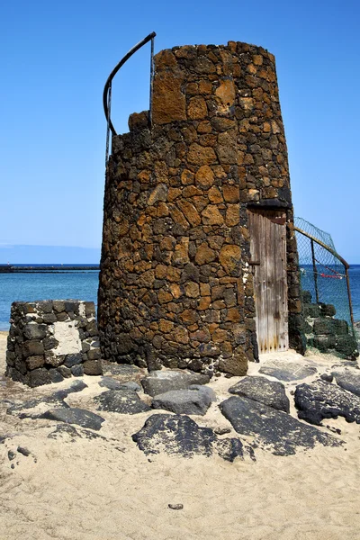 Turm spanien hügel gelb strand schwarz felsen lanzarote — Stockfoto