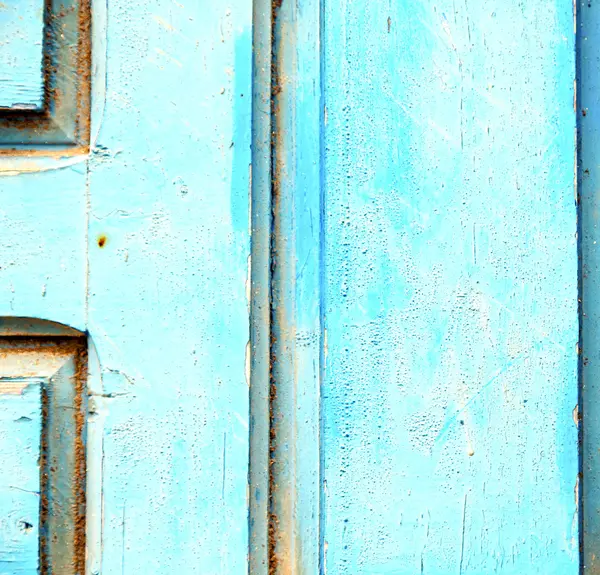 Gestripte verf in de blauwe houten deur en roestige spijker — Stockfoto