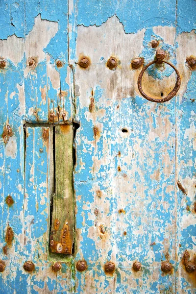 Roestige verf in de blauwe houten deur en Marokko knocker — Stockfoto