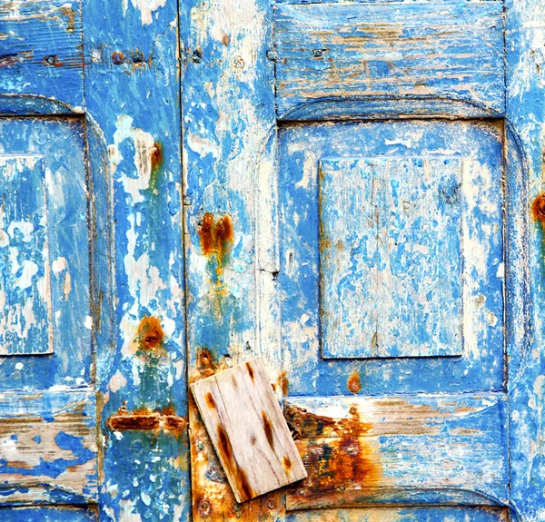 Pintura despojada na porta de madeira azul e prego enferrujado — Fotografia de Stock