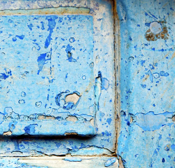Csíkos festék a kék fa ajtó és rozsdás köröm — Stock Fotó