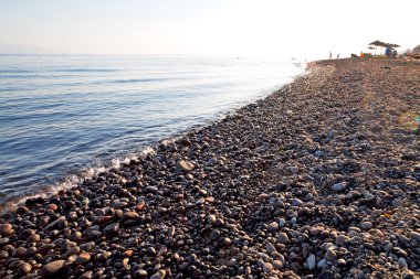 kıyı şeridi gündoğumu ve şemsiye taş