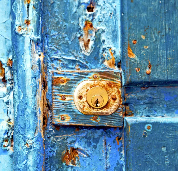 Peinture décapée sale ongle en métal rouillé dans la porte en bois bleu et — Photo