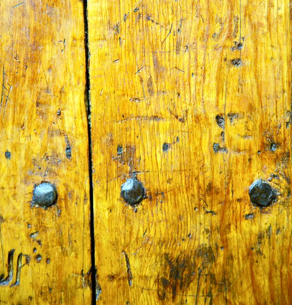 Prego tinta descascada suja na porta de madeira marrom e amarelo enferrujado — Fotografia de Stock