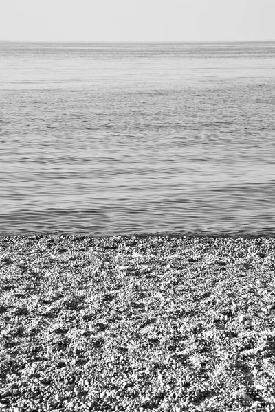 Stone in the coastline sunrise and light ocean white sky — Stock Photo, Image