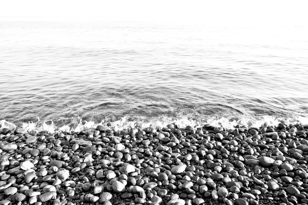 Pedra no litoral nascer do sol e luz oceano céu branco — Fotografia de Stock