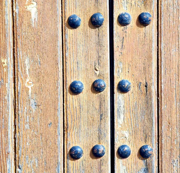 Chiodo di metallo sporco vernice spogliata nella porta di legno rosso marrone e — Foto Stock
