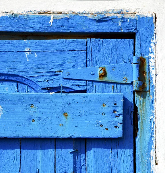 Rusty metal     nail dirty stripped paint in the blue wood door — Stock Photo, Image