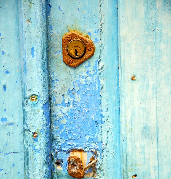 Chiodo in metallo arrugginito vernice sporca spogliata nella porta di legno blu — Foto Stock
