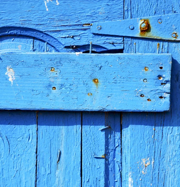 Rusty metal     nail dirty stripped paint in the blue wood door — Stock Photo, Image