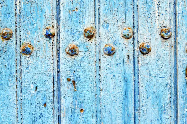 Vernice spogliata nella porta blu e chiodo arrugginito — Foto Stock