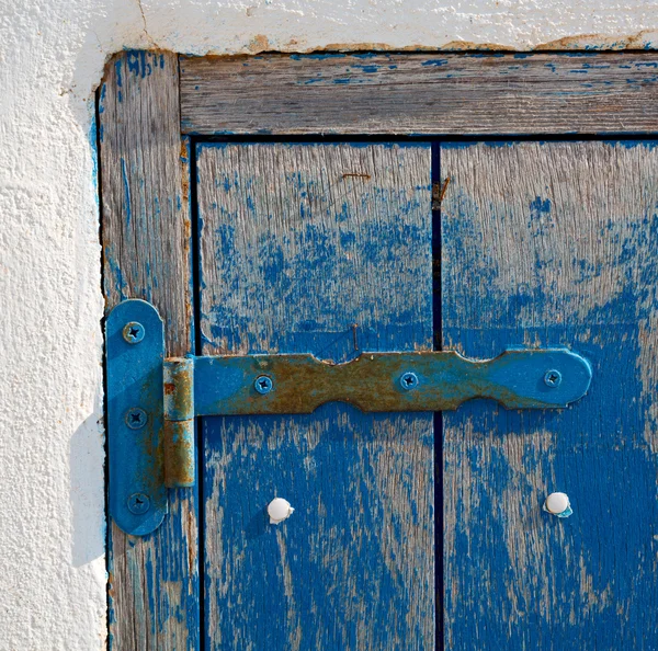 Na parede velha uma janela articulada madeira azul e metal enferrujado — Fotografia de Stock