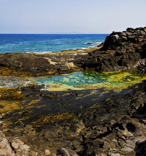 Liggande sten himlen moln klippstrand — Stockfoto