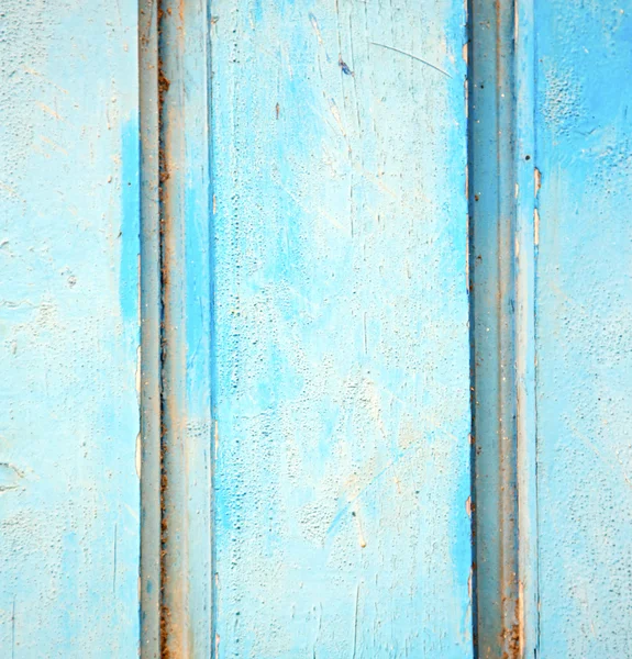 Dirty stripped paint in the blue wood door and rusty nail — Stock Photo, Image