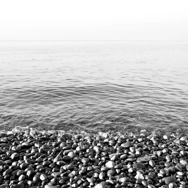 Piedra en la costa amanecer y luz océano cielo blanco — Foto de Stock