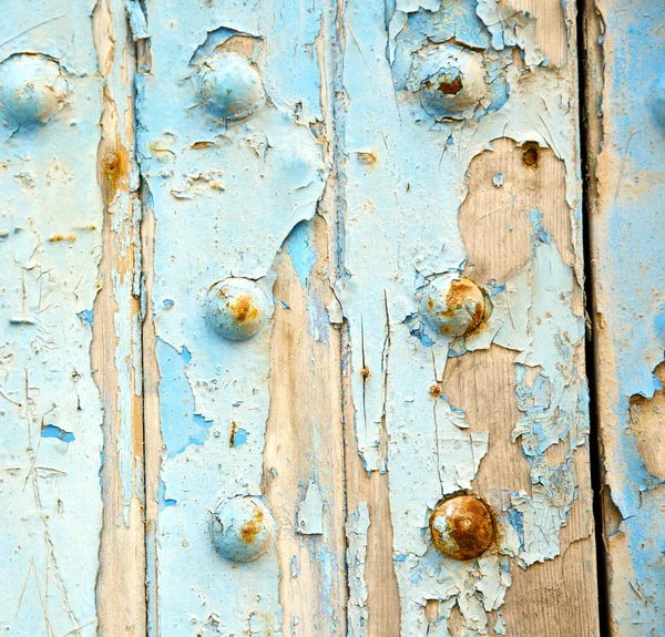 Vernice spogliata nella porta di legno blu e chiodo arrugginito — Foto Stock