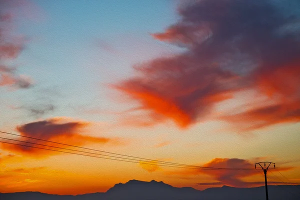 Montagne en Afrique marocaine câbles de courant et lever de soleil rouge — Photo