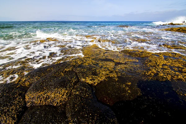 Ljus vatten skum rock Spanien himlen moln stranden — Stockfoto