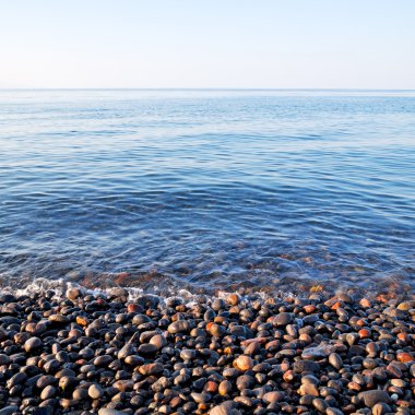 kıyı şeridi gündoğumu ve hafif okyanus beyaz gökyüzü taş