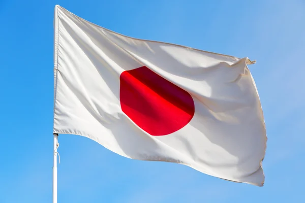Japanb acenando bandeira no céu azul — Fotografia de Stock