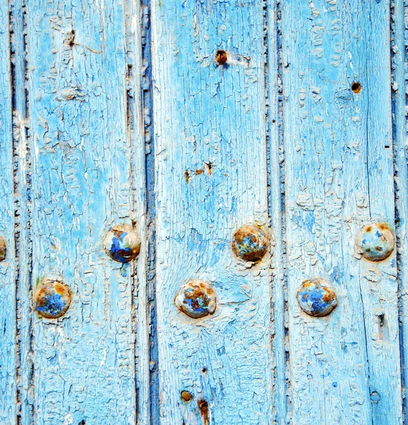 Dirty stripped paint in the blue wood door and rusty nail — Stock Photo, Image