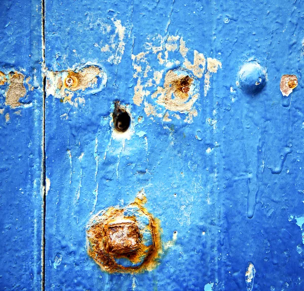 蓝色木门上的剥光的油漆和生锈的钉子 — 图库照片