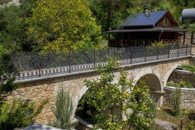 Dağlarda köprüsü olan bir ev