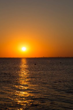 İnsanlar gün batımında deniz kıyısında