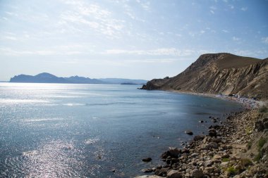 Deniz kıyısı kayalıklarla bir körfeze sıkışmış.