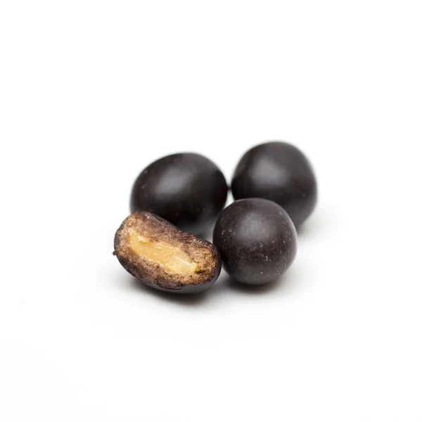 Peanuts in chocolate on the white background — Stock Photo, Image