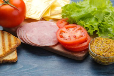 Sandviç. Sandviç, jambon, peynir ve domates yapmak için gerekli malzemeler.