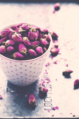 Pembe noktalı fincan kurutulmuş gül tomurcukları metal tepsi dolu