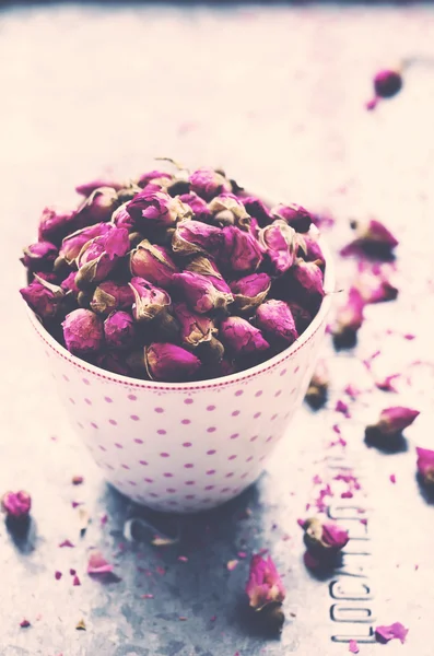 Suszone pąki róży w filiżanki herbaty z pustej przestrzeni na jasnym tle — Zdjęcie stockowe