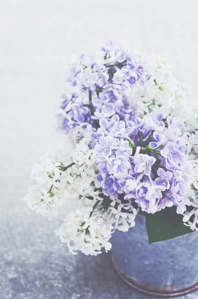 Bouquet of white and purple lilac flowers in metal bowl on grey background — Stock Photo, Image