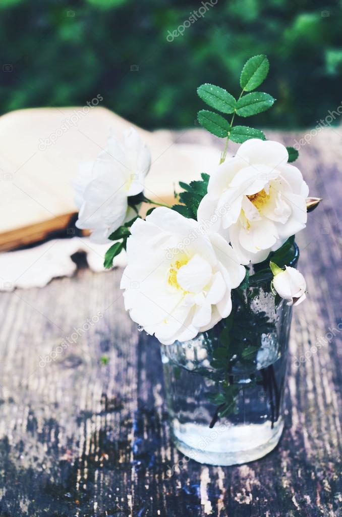 Summer bouquet of white wild roses on a garden table