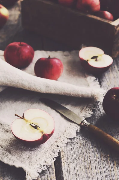 Corte de manzanas con cuchillo sobre fondo de madera — Foto de Stock