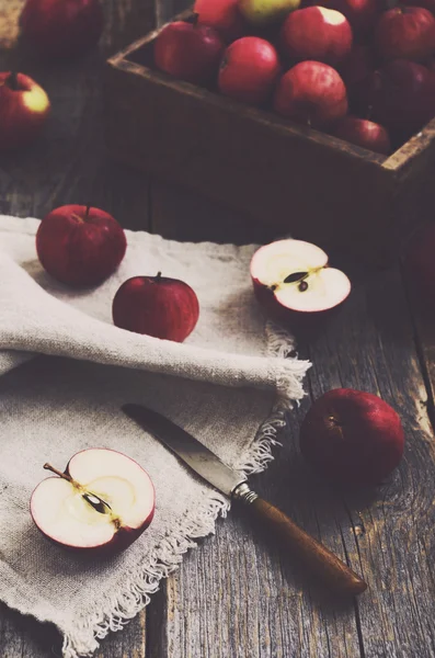 Řezání červené zralé jablko na dřevěné pozadí — Stock fotografie