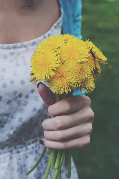 Girl in vintage dress holding bunch of yellow dandelions — Stock Photo, Image