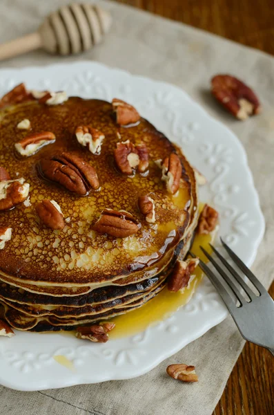 Empilement de crêpes fines maison garnies de miel et de noix de pécan — Photo