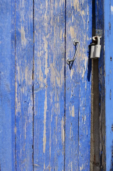 Глубоко синяя ржавая плетеная дверь с металлической ручкой и замком — стоковое фото